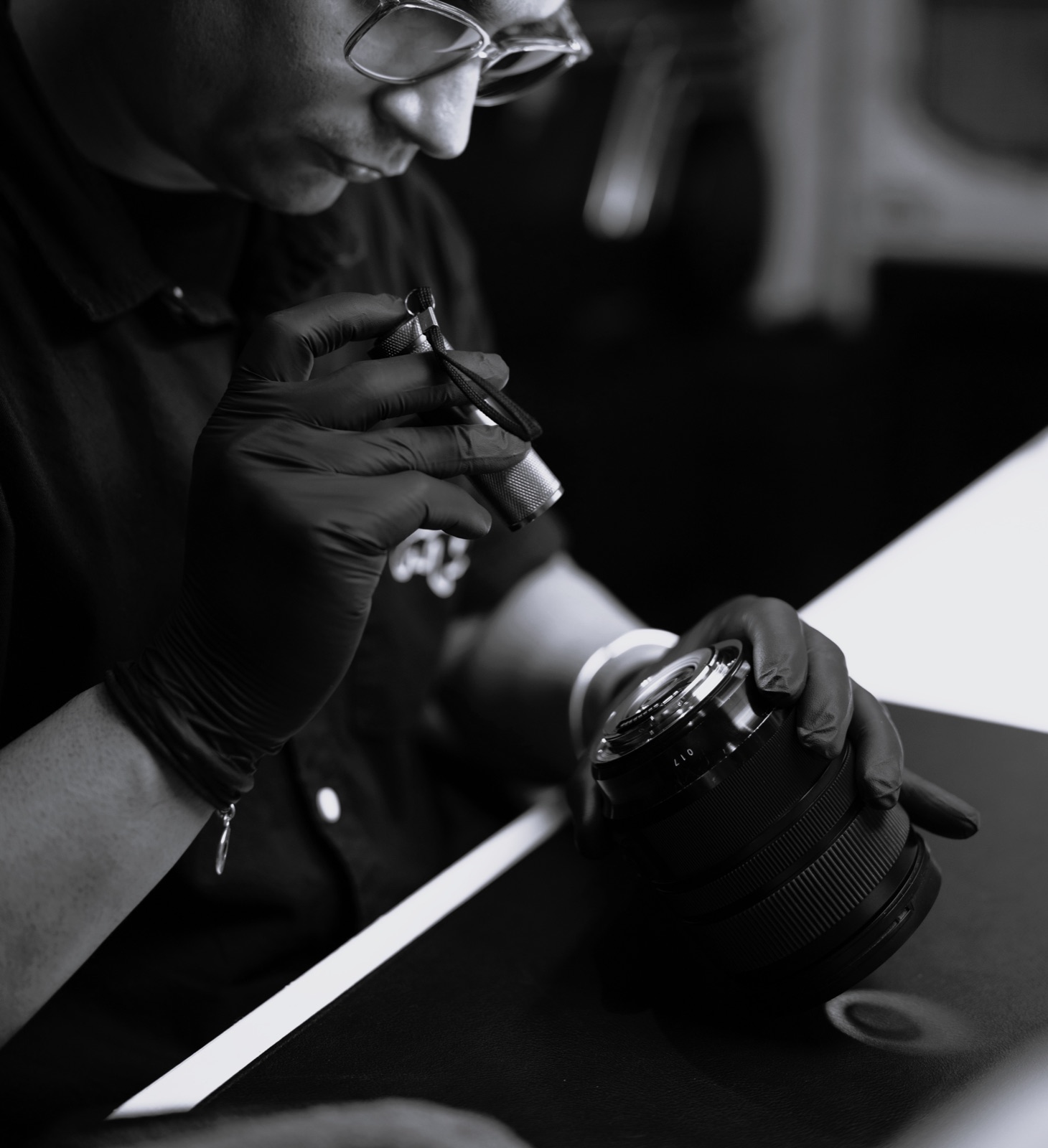 Camera body open on a technician's workbench before cleaning